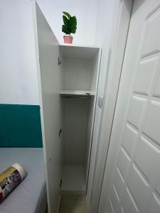 a white closet with a potted plant on top at Short Stay Partition Room in Al Barsha 1 Near Mashreq Metro in Dubai