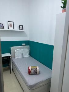 a bed in a room with a green and white wall at Short Stay Partition Room in Al Barsha 1 Near Mashreq Metro in Dubai