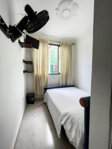 een slaapkamer met een wit bed en een raam bij Hotel California Tropical in La Tebaida