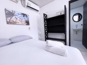 um quarto branco com uma cama e um lavatório em Island Vibes em San Andrés