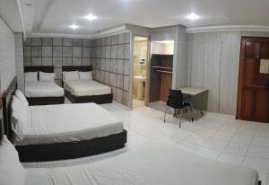 a hotel room with two beds and a desk at HOTEL SAN THOMAS INN in Panama City