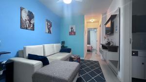 uma sala de estar com um sofá branco e uma parede azul em Apartamento Praia de Navegantes Beto Carrero Balneário Camboriú em Navegantes