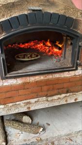 Une pizza est préparée dans un four en briques. dans l'établissement Casa quinta Laguna La Brava La incoronata, à Villa Residencial Laguna Brava