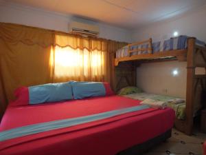een slaapkamer met 2 stapelbedden en een rood bed bij Hotel malecón del Rio in Barranquilla