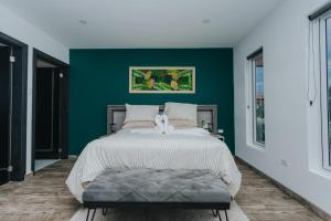 a bedroom with a bed with a green wall at Hidden Villa Aruba in Oranjestad