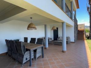 a patio with a wooden table and chairs at Casa do Mundo Madeira in Gaula