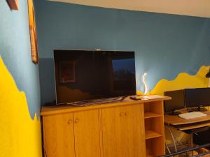 um quarto com uma secretária e uma televisão num armário de madeira em Gästezimmer em Hanôver