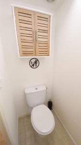 a white bathroom with a toilet with a window at Les Félibriges in Cannes