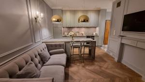 een woonkamer met een bank en een keuken bij Luxury Garden Apartment in Warschau