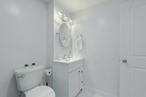 a white bathroom with a toilet and a sink at Serene Elegance 2BR Gem with modern conforts in Calgary