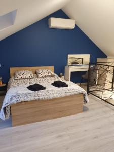 a bedroom with a bed with a blue wall at Les Lunetiers in Champagnole