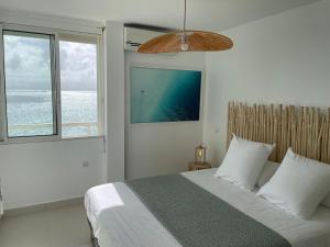 a bedroom with a bed with a view of the ocean at Face à la mer in Le Gosier