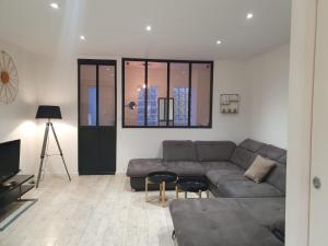 a living room with a couch and a tv at Les Lunetiers in Champagnole