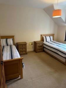 a bedroom with two beds and two night stands at 4 Caberfeidh in Fort William