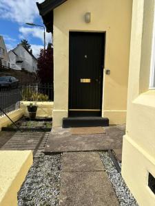 a black door on the side of a house at 4 Caberfeidh in Fort William +13 photos
