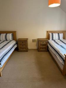 a bedroom with two beds and two night stands at 4 Caberfeidh in Fort William