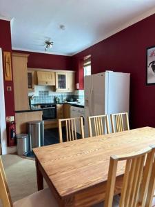 a kitchen with a wooden table and a refrigerator at 4 Caberfeidh in Fort William