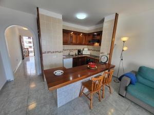 a kitchen and living room with a table and a couch at Victoria Court II in Los Cristianos +13 photos