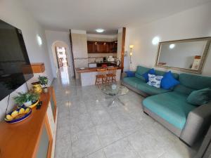 a living room with a blue couch and a kitchen at Victoria Court II in Los Cristianos
