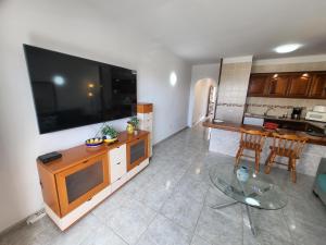 a living room with a large flat screen tv on a wall at Victoria Court II in Los Cristianos