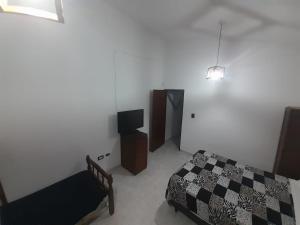 1 dormitorio con 1 cama y TV en La Martina en Villa Carlos Paz