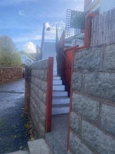 a staircase leading to a house with a red fence at The Nest at Wynncroft in Torquay