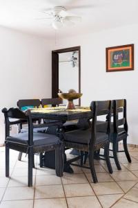 mesa de comedor con sillas negras y espejo en Casa AMAR·i·LLA Céntrica, en Guadalajara