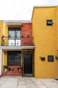 un edificio amarillo con puerta y balcón en Casa AMAR·i·LLA Céntrica, en Guadalajara