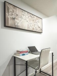 a white desk with a laptop and books on it at Serene Elegance 2BR Gem with modern conforts in Calgary