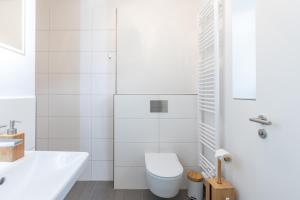 Un baño blanco con inodoro y lavabo. en Westwind, en Tönning