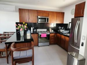 una cocina con armarios de madera y una mesa con flores. en Casa NUEVA ¡San José del Cabo!, en San José del Cabo