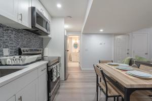 a kitchen and dining room with a wooden table at Serene Elegance 2BR Gem with modern conforts in Calgary