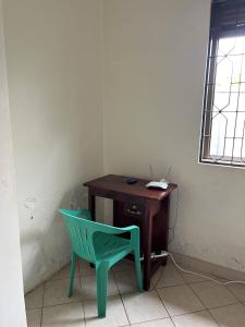 una silla verde junto a un escritorio de madera en Inviting 3-Bed House in Akright City Jennifers, en Buzzi
