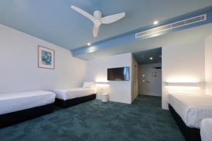 um quarto de hotel com 2 camas e uma ventoinha de tecto em The Lodge, Blacktown - Sydney em Rooty Hill