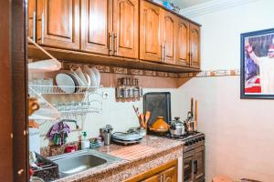 una cocina con armarios de madera y fregadero en Simons house en Marrakech