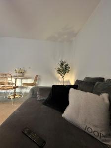 ein Wohnzimmer mit einer Couch mit Fernbedienung darauf in der Unterkunft Apartment Laurier in Alsdorf