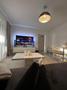 a living room with a table and a tv at Apartment Laurier in Alsdorf