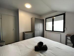 einen Hut auf einem Bett in einem Schlafzimmer in der Unterkunft Family Duplex 3BR au Coeur de Talange in Talange