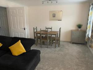 a living room with a table and a couch at Great Location, large 1 bed flat with parking in Broughty Ferry