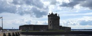 an old building with a tower in front of the water at Great Location, large 1 bed flat with parking in Broughty Ferry