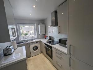 a kitchen with a washer and dryer in it at Great Location, large 1 bed flat with parking in Broughty Ferry