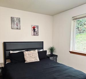a bedroom with a black bed and a window at Meritage in Corvallis