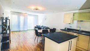 a kitchen and living room with a table and chairs at Modern Spacious 2-Bed Apartment in London in Bromley