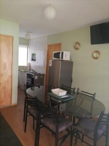 eine Küche mit einem Tisch und Stühlen sowie einem Kühlschrank in der Unterkunft Las Tinajas de Vega Ancoa in Linares