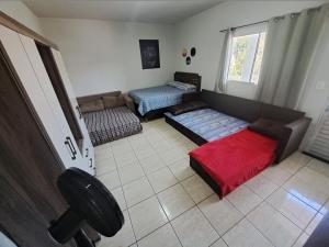 a living room with two beds and a couch at Condomínio Vitória in Vila Velha