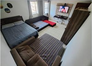 a living room with a bed and a television at Condomínio Vitória in Vila Velha