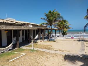 ein Haus am Strand mit Palmen und dem Meer in der Unterkunft Pousada Marinheiro in Sítio