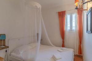 a bedroom with a white bed with a mosquito net at Country villa on Montargil in Montargil