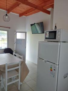a kitchen with a microwave on top of a refrigerator at La casita del campo in Colón
