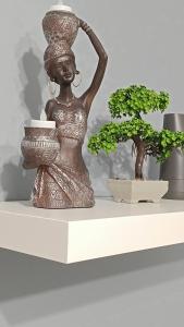 a statue of a woman on a shelf with a plant at M&M's house in Thessaloniki